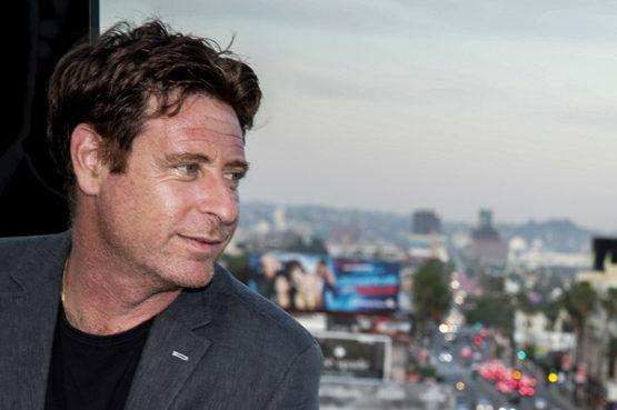 Stuart Chelin, a Los Angeles Lawyer, posing by a window looking out over the city