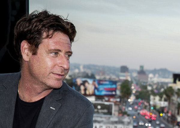 Stuart Chelin, a Los Angeles Lawyer, posing by a window looking out over the city