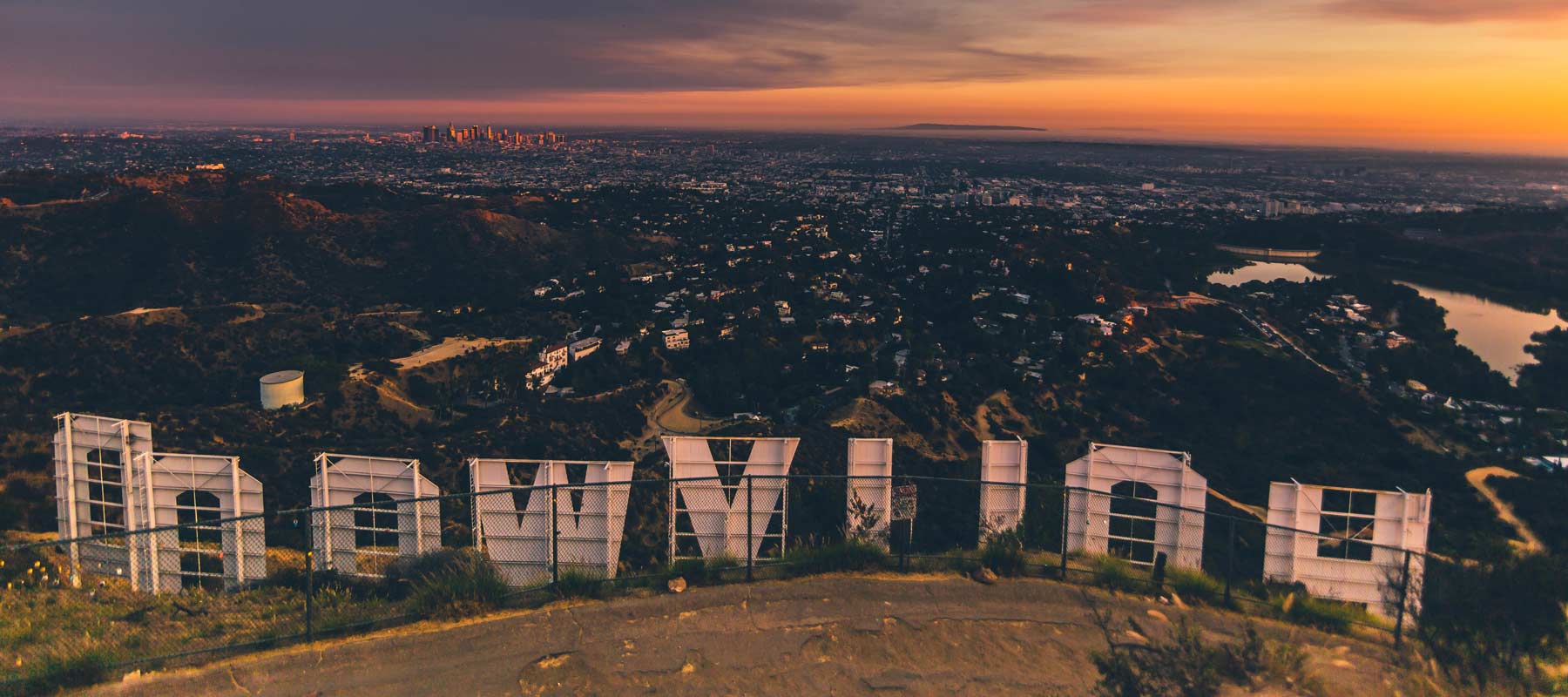 view of los angeles from behind the hollywood sign at dusk