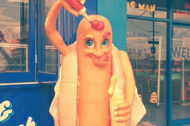 cartoon hot dog statue pouring ketchup on itself