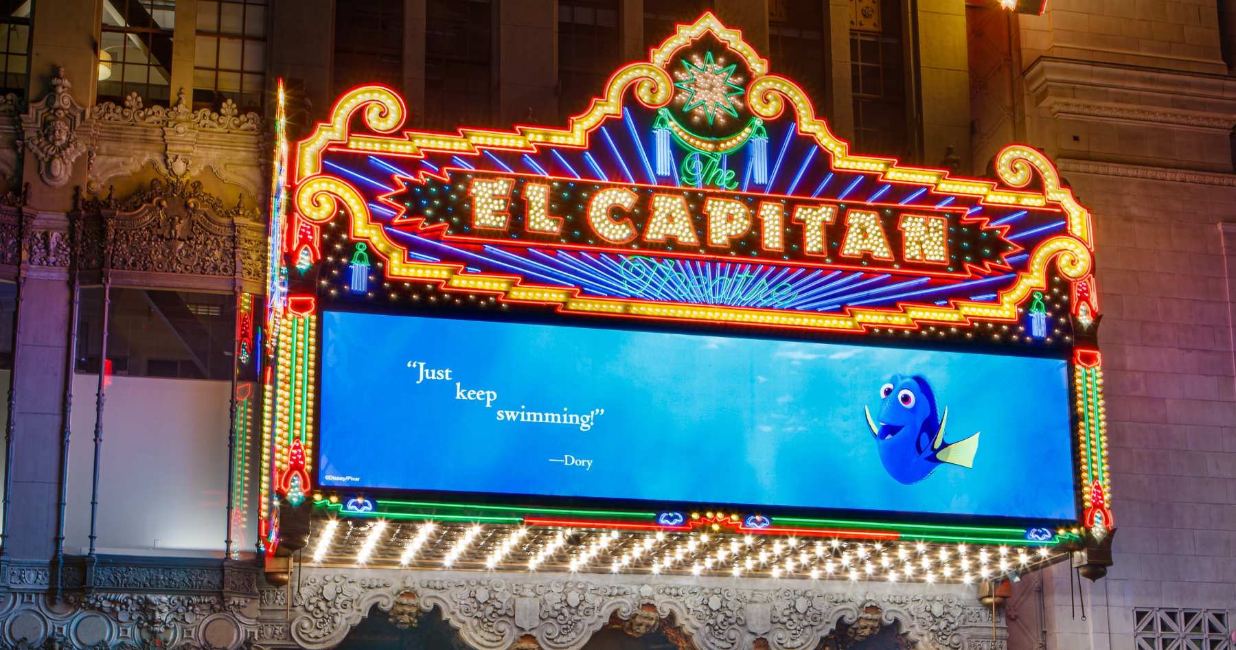 old time movie theatre displaying a billboard captioned just keep swimming